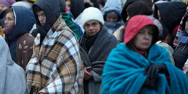 Flüchtlinge, hauptsächlich Frauen und Kinder, warten in einer Menschenmenge auf den Transport, nachdem sie aus der Ukraine geflohen sind und am 7. März 2022 am Grenzübergang in Medica, Polen, angekommen sind.