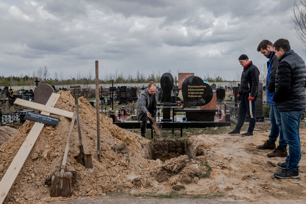 Burying bodies in a cemetery in Bucha, Ukraine, on Tuesday.