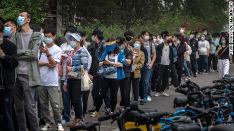 Die Menschen stehen am Montag an einem temporären Teststandort im Chaoyang-Distrikt in Peking für Covid-Tests an.