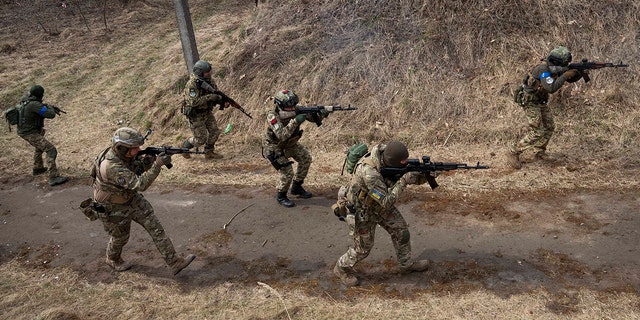 Ukrainische Soldaten der 103. Separaten Brigade der regionalen Verteidigung der Streitkräfte feuern ihre Waffen während einer Trainingsübung an einem unbekannten Ort in der Nähe von Lemberg in der Westukraine ab, Dienstag, 29. März 2022 (AP Photo/Nariman El-Mufti)