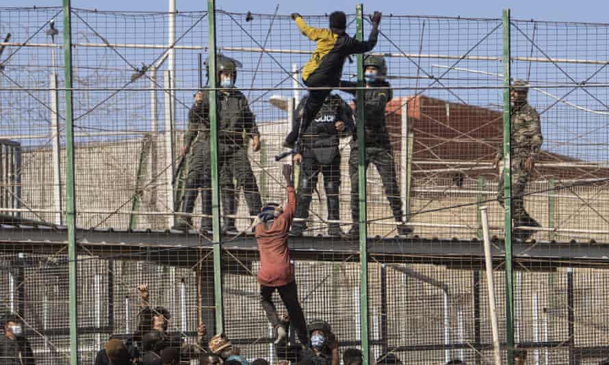 Migranten erklimmen die Mauern, die Melilla und Marokko trennen