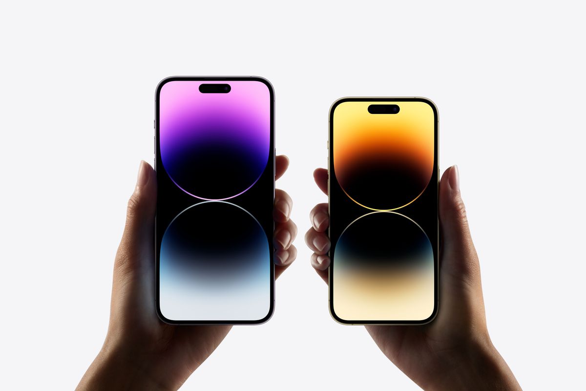 Das iPhone 14 Pro und das iPhone 14 Pro Max werden nebeneinander gehalten, ihre Bildschirme zeigen einen farbigen Hintergrund.