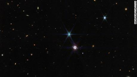 Auf diesem Foto von Webb & # 39;  s Nahinfrarotkamera, eine kleine Gruppe von Hunderten von Hintergrundgalaxien, die sich in Größe und Form unterscheiden, erscheint neben Neptun.